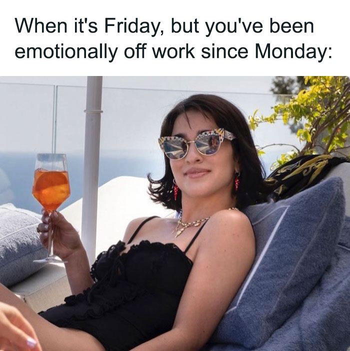 Woman lounging with a drink, wearing sunglasses, embodying a happy Friday vibe.