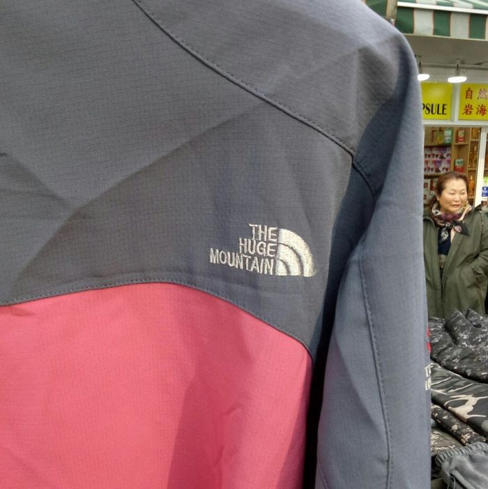 Jacket with a hilariously bad rip-off logo The Huge Mountain, parodying well-known outdoor brand designs.