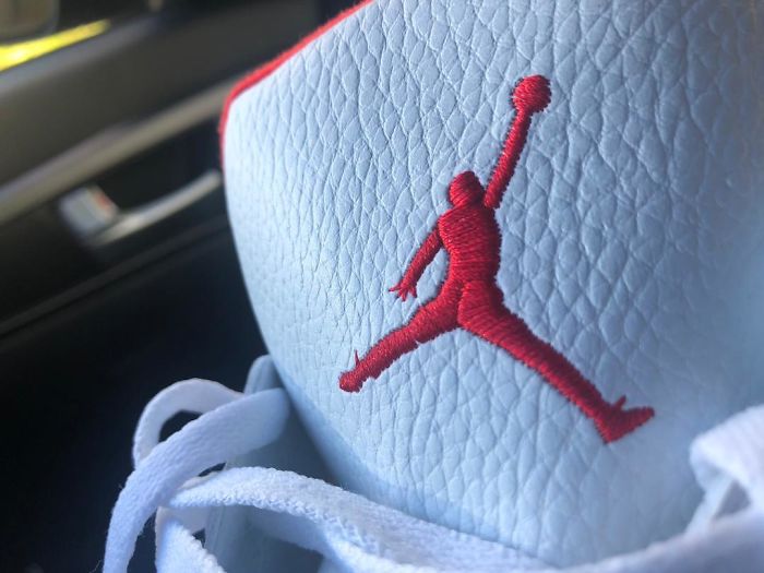 Close-up of a sneaker with a red embroidery logo resembling a famous brand, illustrating hilariously bad rip-offs.