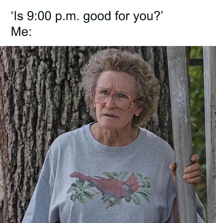 Elderly woman in glasses stands outside, looking skeptical, wearing a gray T-shirt with a bird design; relatable meme humor.