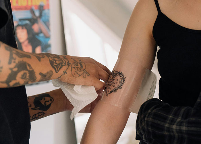 Tattoo artist finishing a woman's arm tattoo in a studio, focusing on boundaries. Tattoo artist finishing a woman's arm tattoo in a studio, focusing on boundaries.