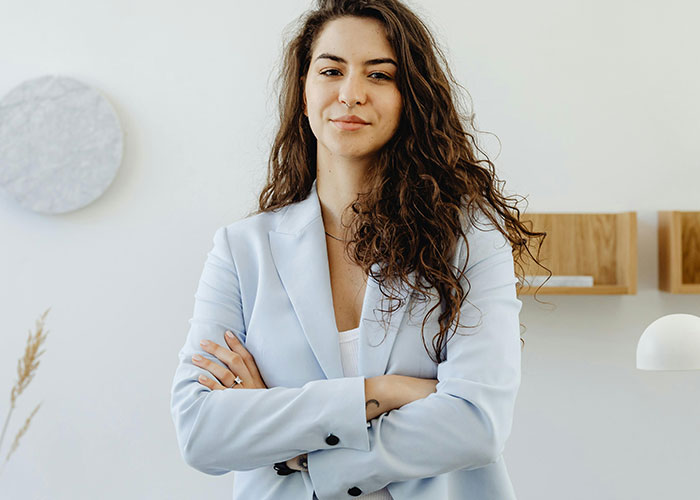 Confident young woman standing with arms crossed, representing people who realized their new job was a mistake.