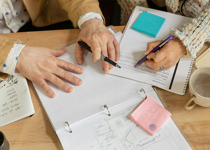 Two colleagues reviewing documents and notes, illustrating moments people realized their new job was a mistake.