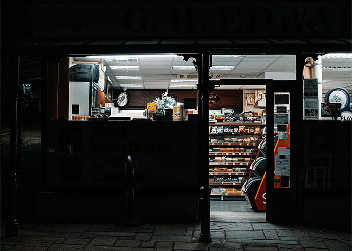 Dimly lit small shop interior at night, depicting a quiet workplace where people realized their new job was a mistake and left.
