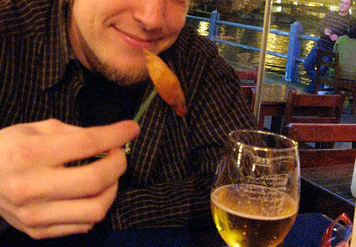 Person enjoying a meal and drink at an outdoor restaurant, illustrating funny stereotypes about people's home countries.