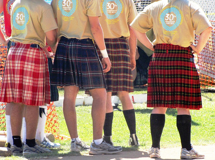 Group of people wearing different patterned kilts, illustrating stereotypes about people’s home countries.