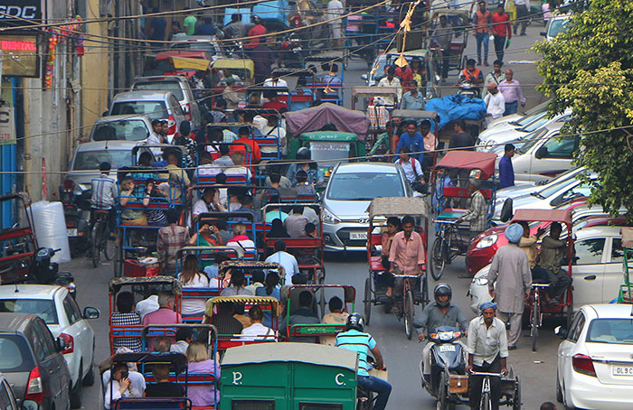 Busy street scene with crowded rickshaws and vehicles depicting stereotypes about people’s home countries.