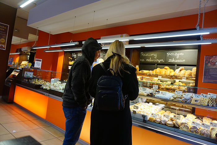 Two people at a bakery counter examining baked goods, illustrating stereotypes about people’s home countries.