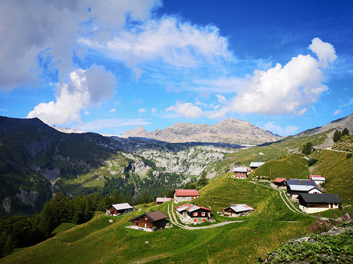 Mountain village landscape with small houses under blue sky, illustrating hilarious stereotypes about people's home countries.