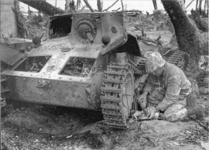 U.S. Marine Provides Water To A Stray Kitten Found Hiding Under A Knocked Out Japanese Type 95 Ha-Gō Light Tank On The Tarawa Atoll On November 24, 1943