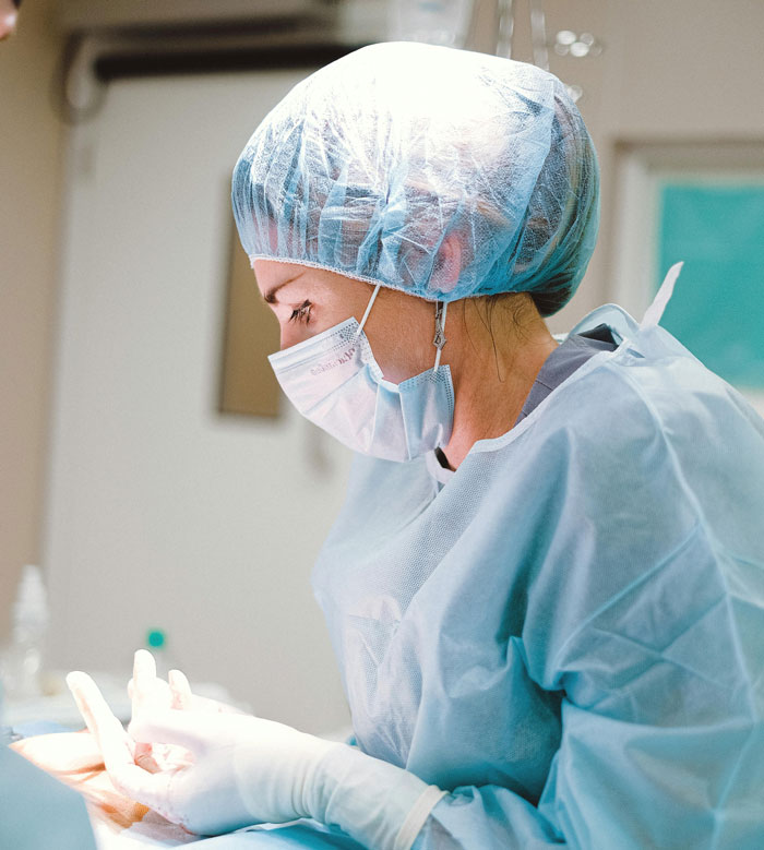 Medical professional wearing protective gear performing a precise task, illustrating lifetime supply stories with varied outcomes.
