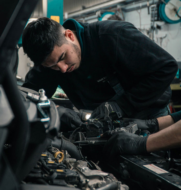 Mechanic focused on fixing car engine components, symbolizing lifetime supply winnings related to automotive maintenance stories.