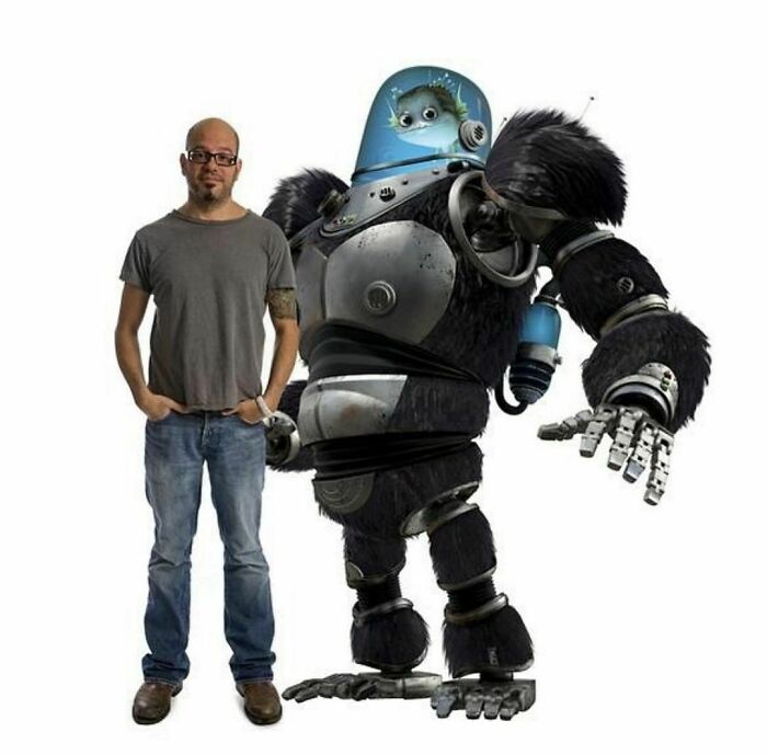 A man stands confidently beside a futuristic robot gorilla in a striking pose, showcasing creativity and bold design.