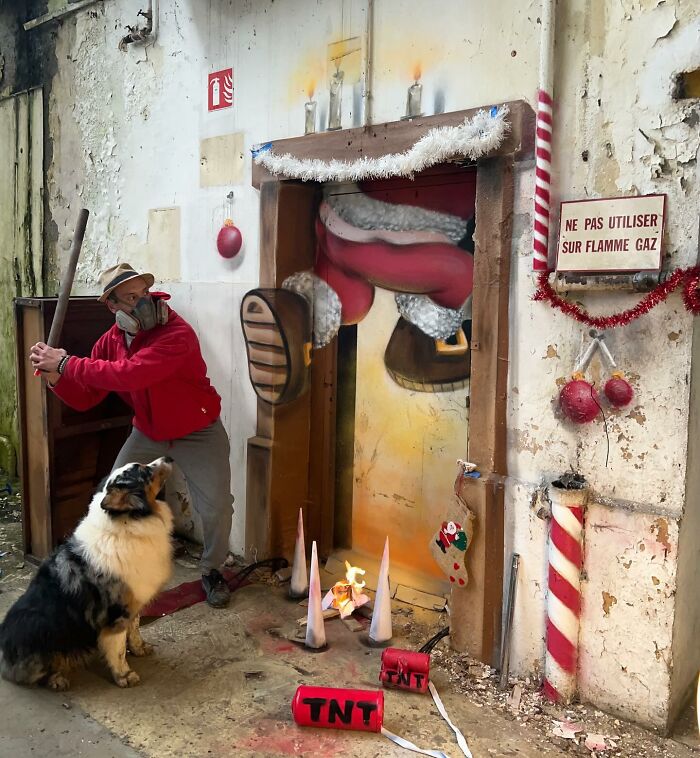 Artist from France wearing red creating incredible 3D graffiti with Christmas theme and dog watching nearby inside old building.