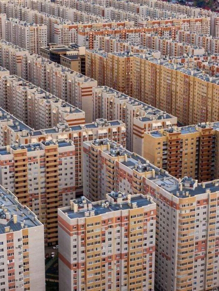 A vast cluster of tall apartment buildings creating a dense, overwhelming scene causing megalophobia fear.