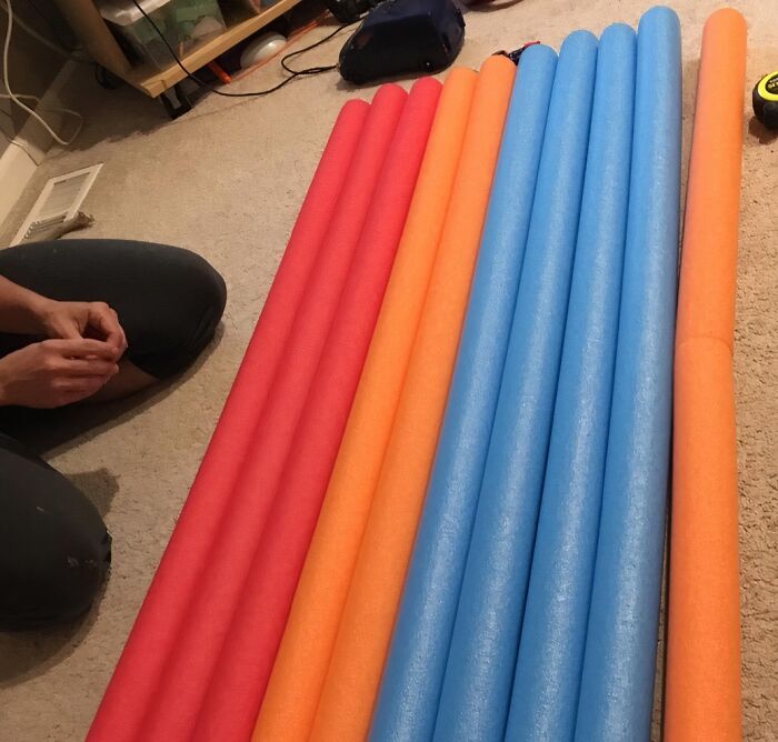 Person sitting on the floor arranging colorful pool noodles as part of creative life hacks that prove hacks aren’t just for lazy people