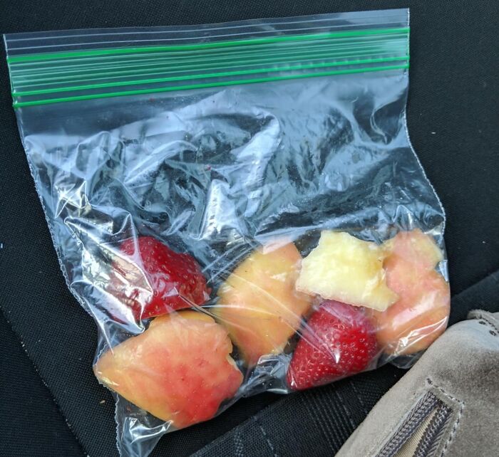 Reusable plastic bag with fresh fruit pieces inside, demonstrating practical life hacks for easy food storage and transport.