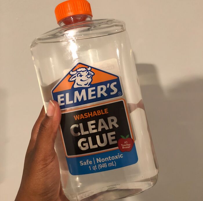 Hand holding a bottle of Elmer's washable clear glue, demonstrating practical life hacks for everyday use.