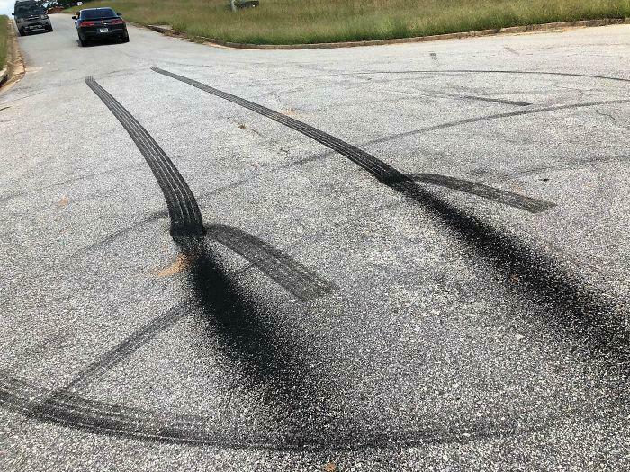 Confusing tire marks on a road create an optical illusion, requiring a double take to figure out the vehicle's path.