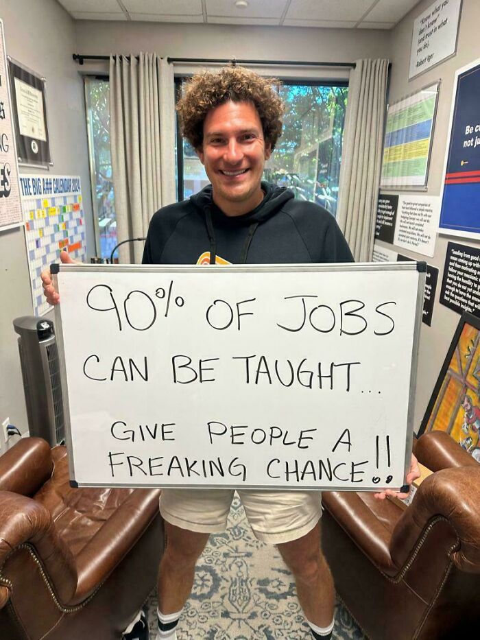 Man holding a sign about job training, illustrating a job hunting challenge in recruitment settings.