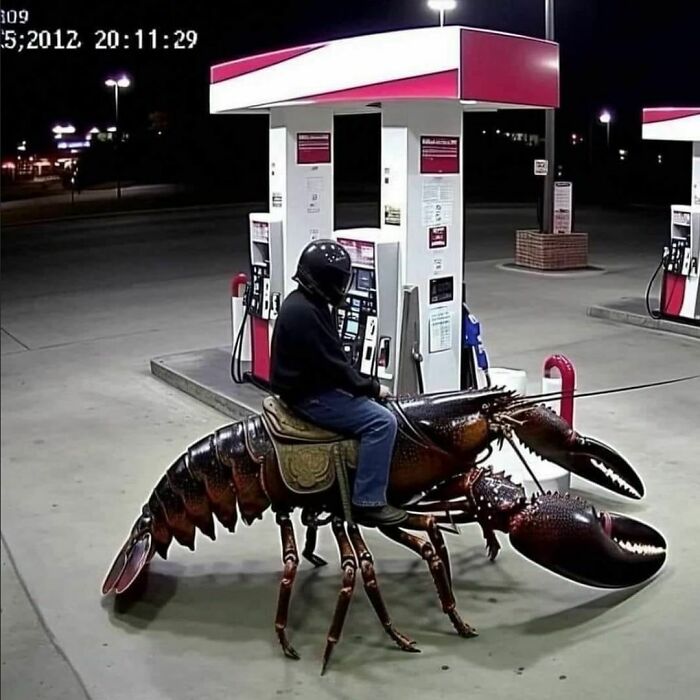 Person at a gas station riding a giant lobster sculpture.