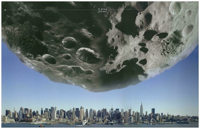 Massive asteroid with detailed craters looming over city skyline, triggering fear for anyone with megalophobia.