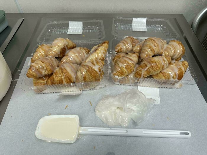 Croissants with extra icing in plastic containers, showcasing food service workers' compliance with customer requests.