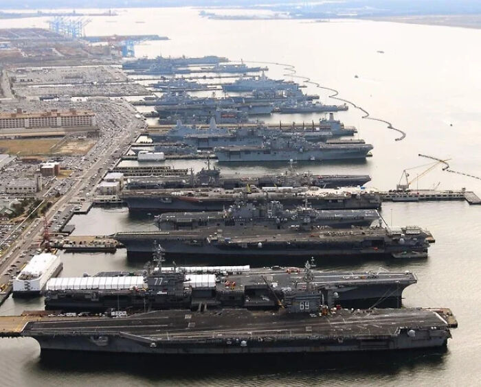 Aerial view of multiple massive aircraft carriers docked, showcasing enormous size and scale for megalophobia fear.