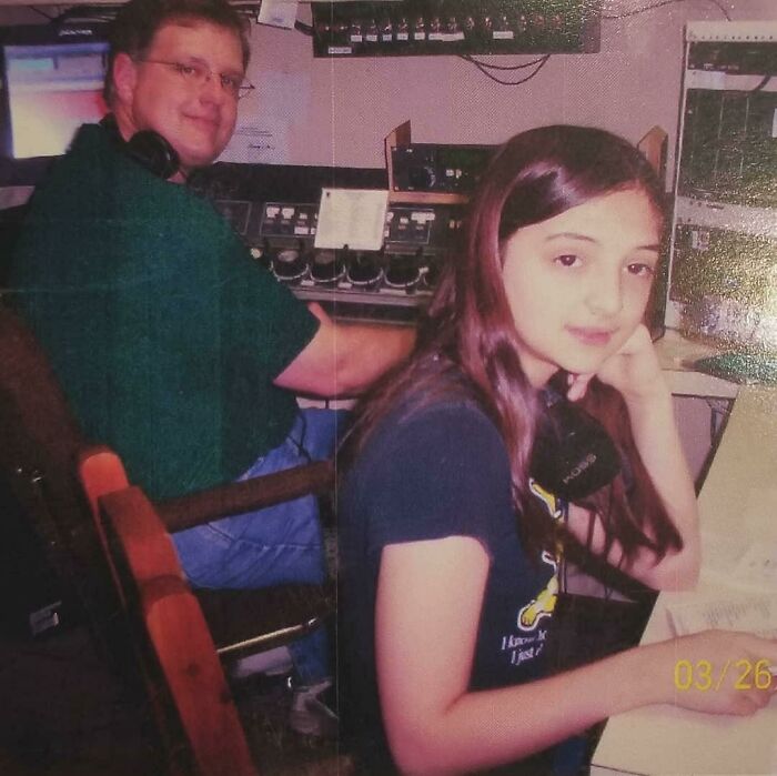 Young girl and man in a recording studio surrounded by vintage audio equipment in a cringy childhood photo.