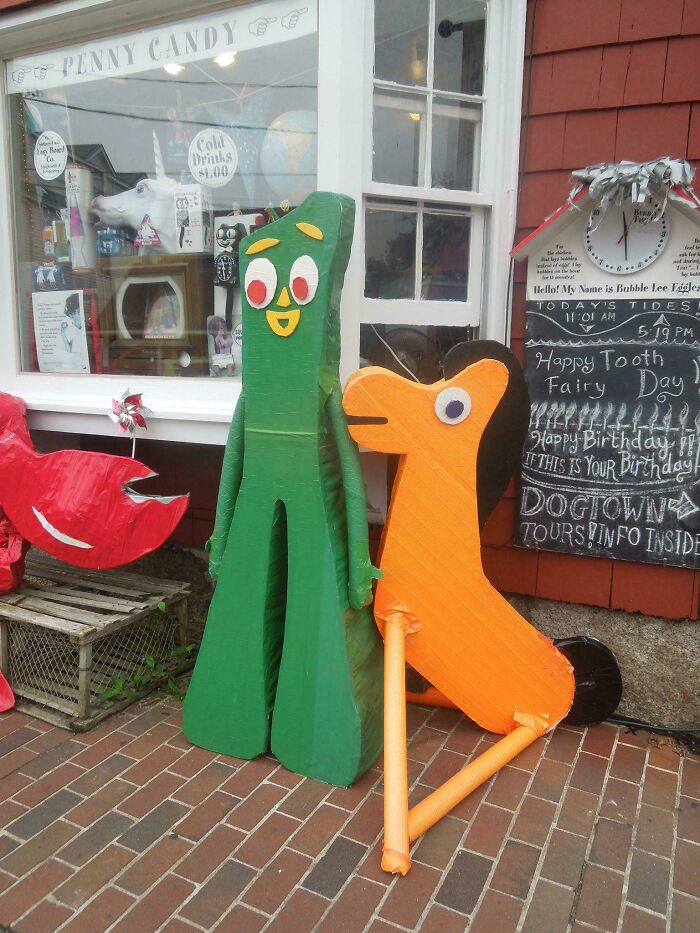 Colorful vintage Gumby and orange dog wooden figures outside a penny candy store, evoking nostalgia and creaking joints memories.