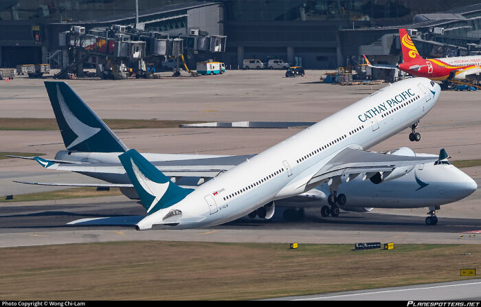 Two Cathay Pacific planes appearing confusingly intertwined on the runway, prompting a double take.