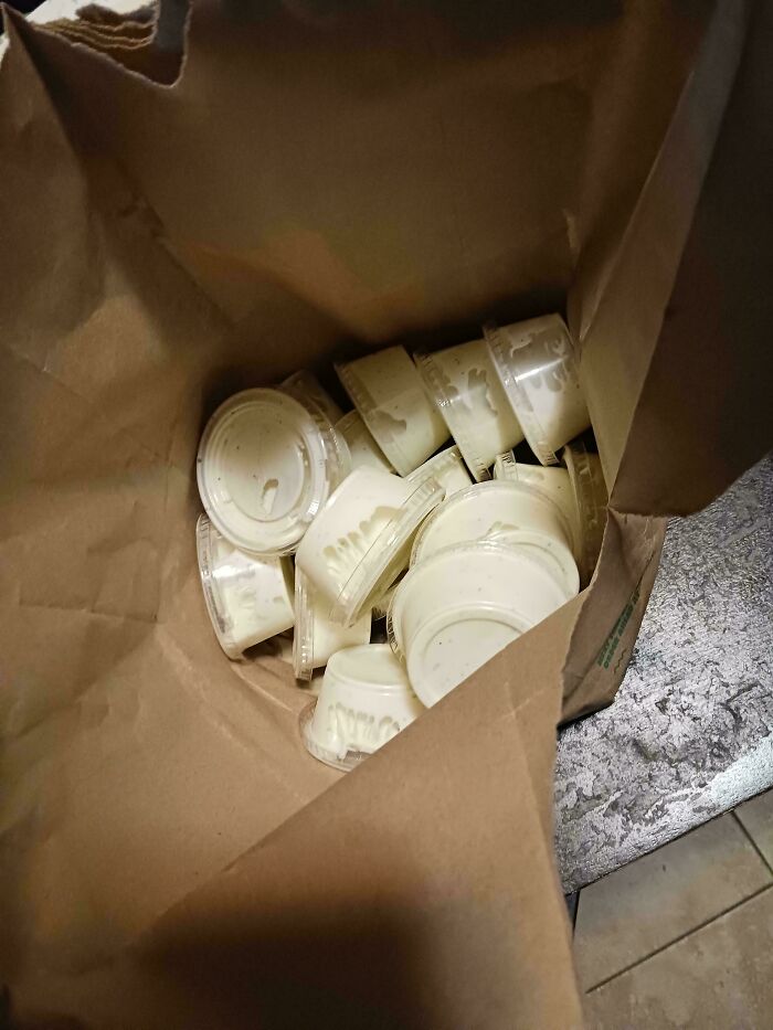 Bag filled with extra sauce cups, showcasing food service workers' compliance with customer requests.