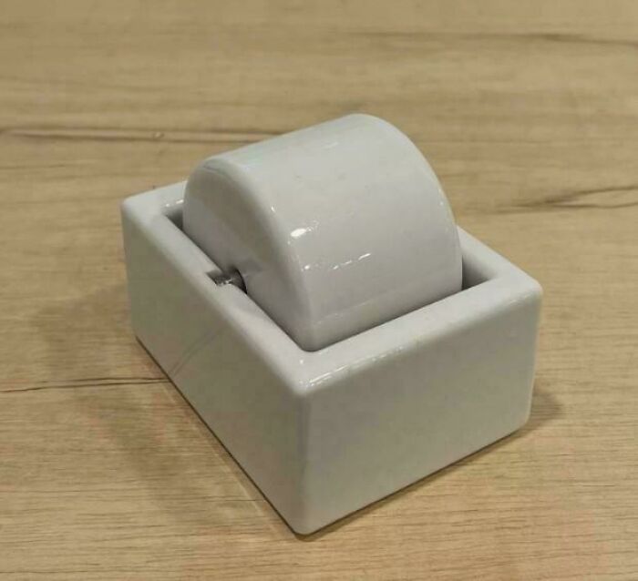 Vintage white ceramic tape dispenser on wooden surface, a nostalgic item for those with creaking joints memories.