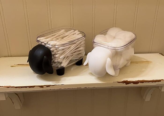 Two sheep-shaped containers holding cotton swabs and cotton balls on a rustic white shelf, weirdly wonderful finds.