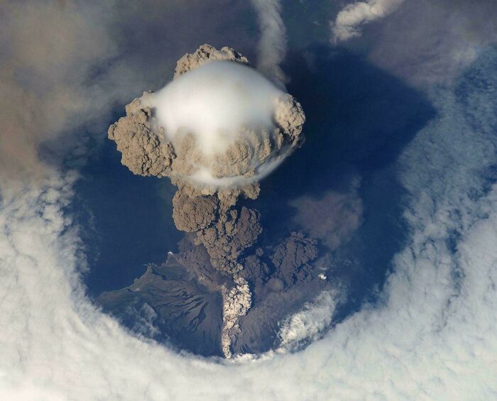 Aerial view of a massive volcanic eruption with towering ash clouds striking fear for those with megalophobia.