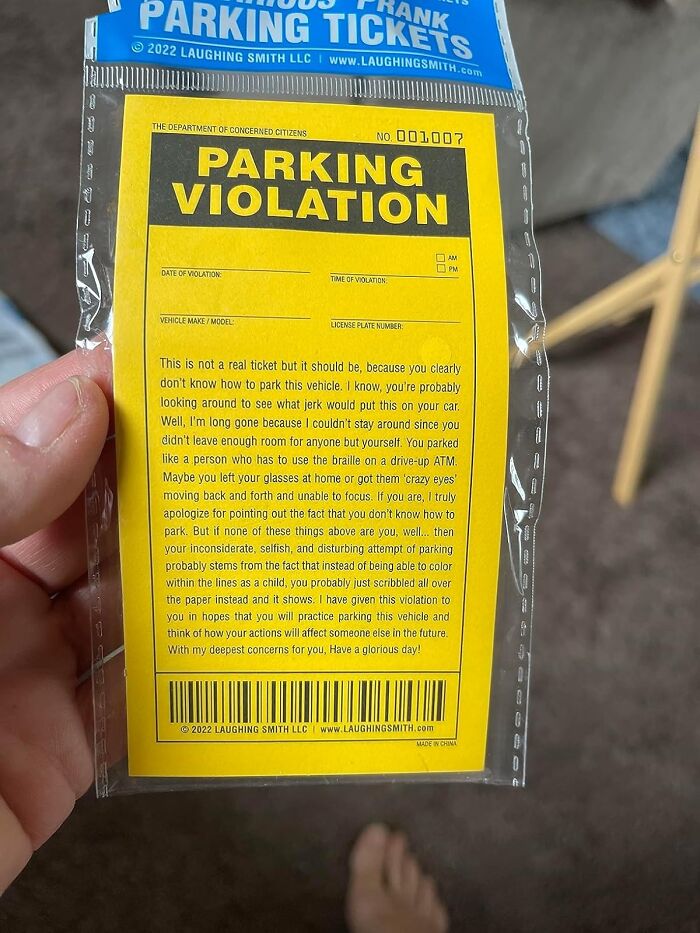 Novelty parking violation prank ticket from LaughingSmith, held in a hand, designed for harmless April Fools fun.