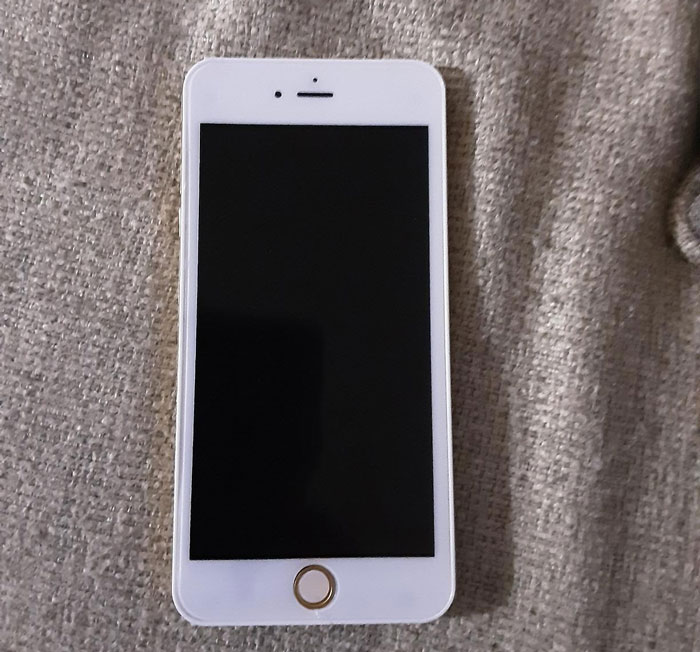 White smartphone placed on a textured surface, screen off, perfect setup for friendly April Fools pranks.