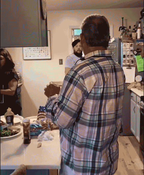 Family laughing in a kitchen during a lighthearted April Fools prank, with people smiling and enjoying the moment.