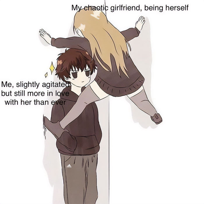  A love meme featuring an anime-style drawing of a couple. The girl, labeled "My chaotic girlfriend, being herself," is playfully hanging off the boy's shoulders, her arms and legs wrapped around him. The boy, labeled "Me, slightly agitated but still more in love with her than ever," stands with a slightly annoyed yet affectionate expression. The background is plain white, emphasizing the characters.