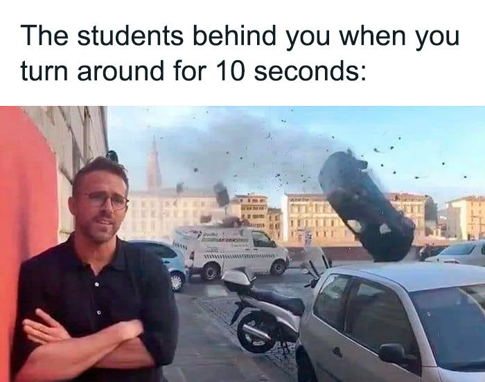 Man with glasses standing calmly as a car flips dramatically behind him, illustrating teacher hardships.