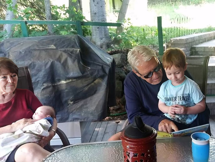 Cool Grandpa Reading To Alistair While Cool Grandma Holds Little Declan