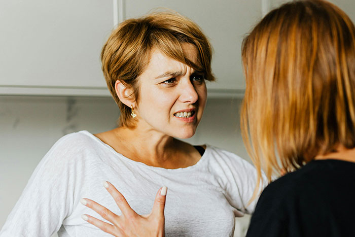 Woman with short hair angrily confronting another person, illustrating a terrifying example of helicopter parenting.