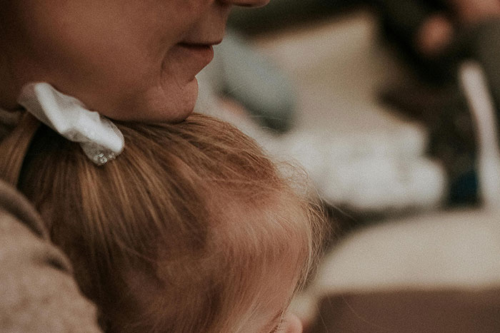 Close-up of a parent holding a child closely, illustrating a typical example of helicopter parenting behavior.