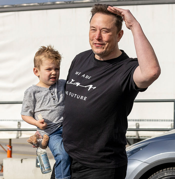 Father holding child outside, smiling, wearing casual attire, related to legal battle and court case involving kids.