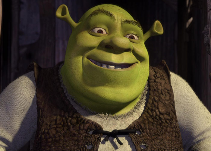 Shrek, a green animated ogre, smiling inside a wooden cabin, representing surprising film adaptations.