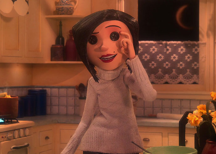 Stop-motion character from a surprising film adaptation sitting in a cozy kitchen at night with a crescent moon outside.