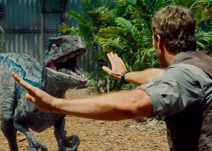 A tense scene showing a man confronting a dinosaur, highlighting surprising film adaptations from popular books.