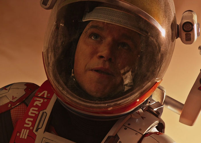 Astronaut in a space suit looking upward with a reflective helmet, scene from a film adaptation that outdid its book.
