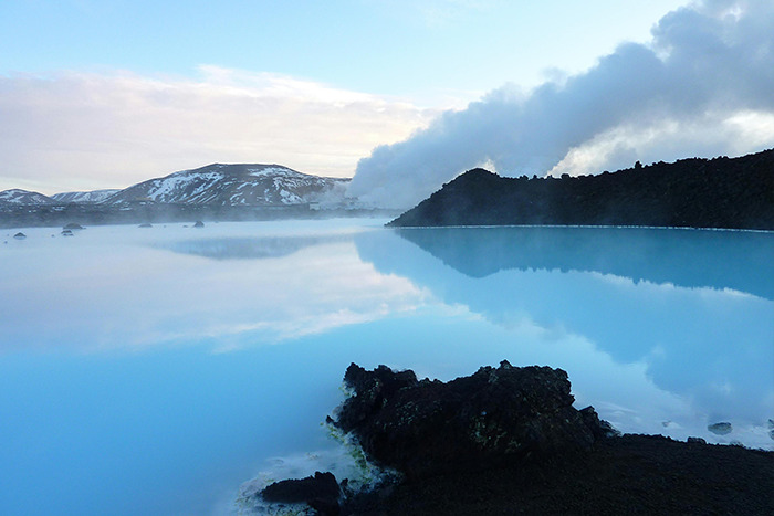 Geothermal blue lagoon in Iceland with milky turquoise water, steam and black lava rocks, a place visited and adored.