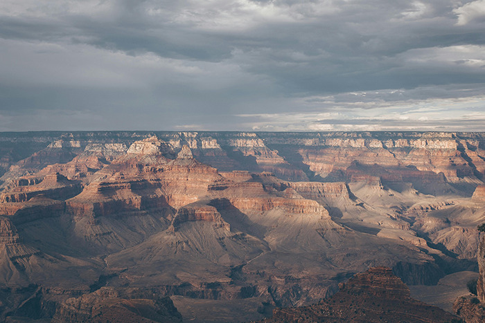 Grand Canyon panorama under cloudy sky, vast layered rock formations — a spectacular place visited that exceeded the hype.